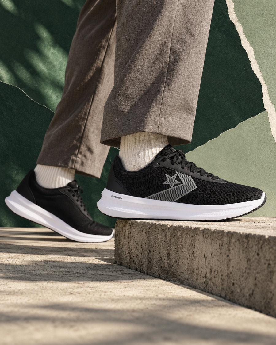 Black Converse trainers with grey tailoring in a green editorial setting
