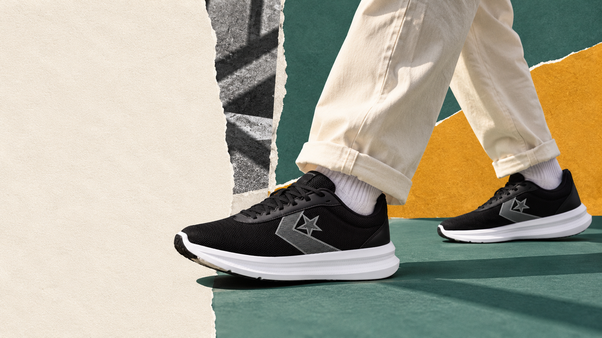 Black Converse Commonstar trainers styled with cream trousers against teal and amber paper